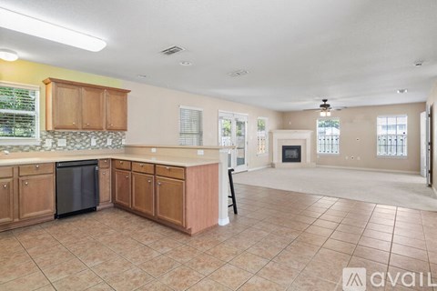 A kitchen with wooden cabinets and a black dishwasher.