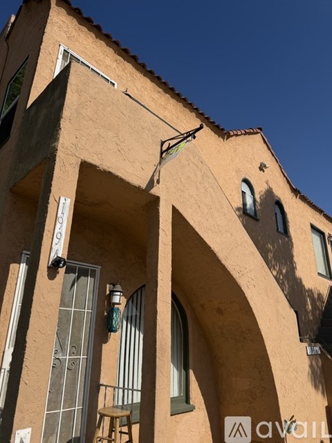 A tan building with a balcony and a window.