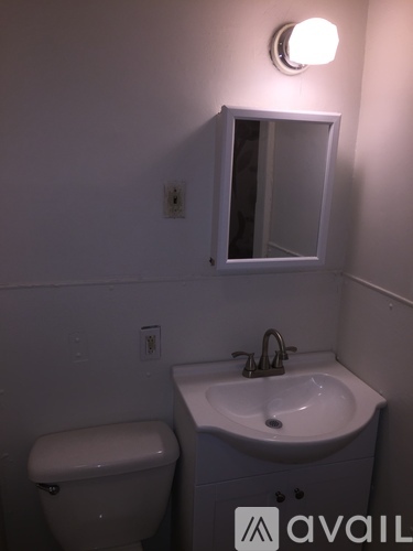 A white toilet sits next to a sink in a small bathroom.