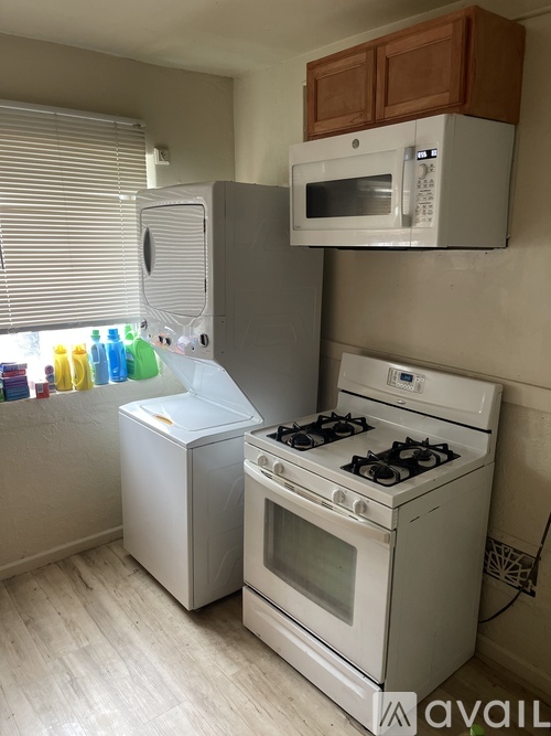 A kitchen with a white stove and a white refrigerator.