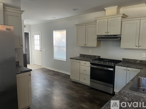 A kitchen with white cabinets and a black stove top oven.