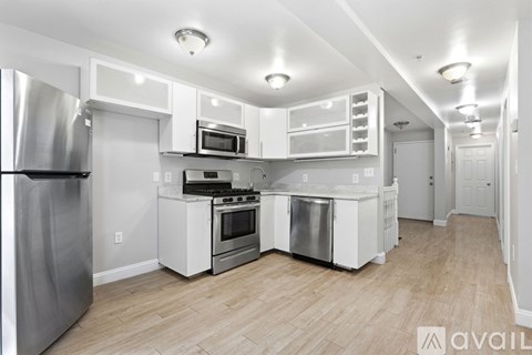 A kitchen with white appliances and cabinets.