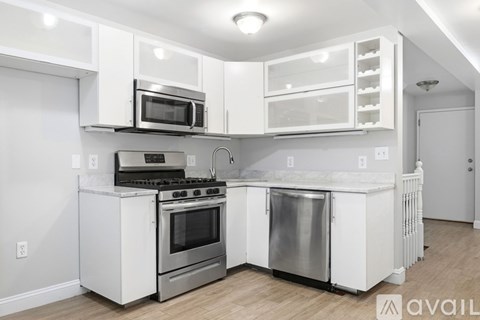 A kitchen with white appliances and cabinets.