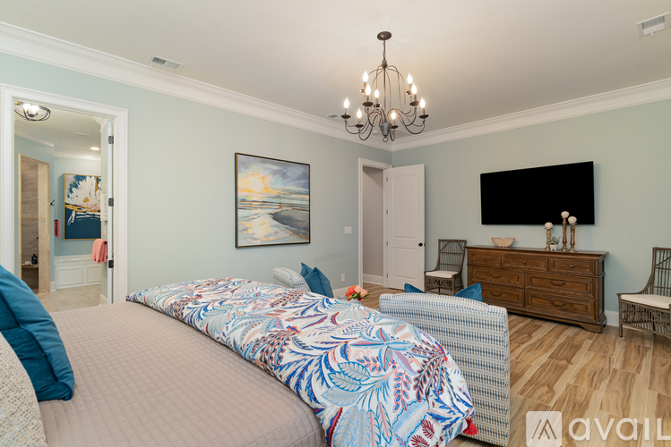 A bedroom with a large bed and a chandelier.