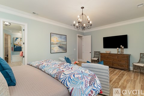 A bedroom with a large bed and a chandelier.