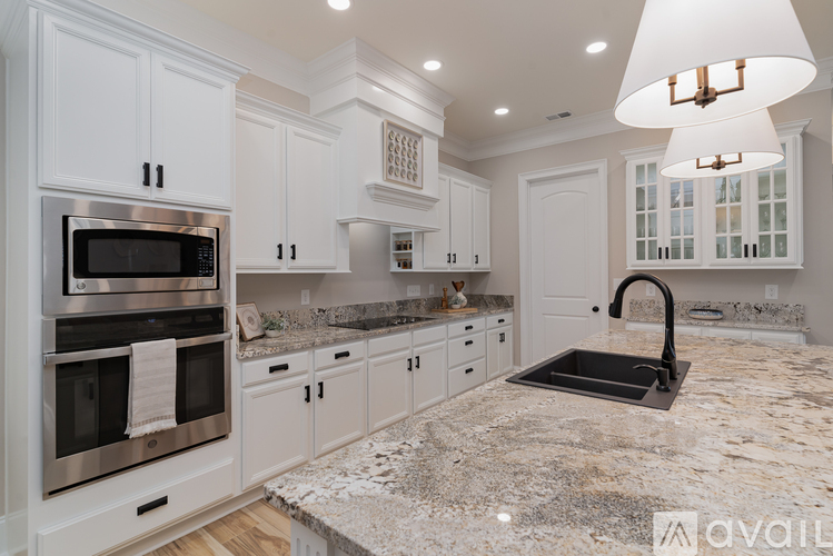 A modern kitchen with granite countertops and stainless steel appliances.