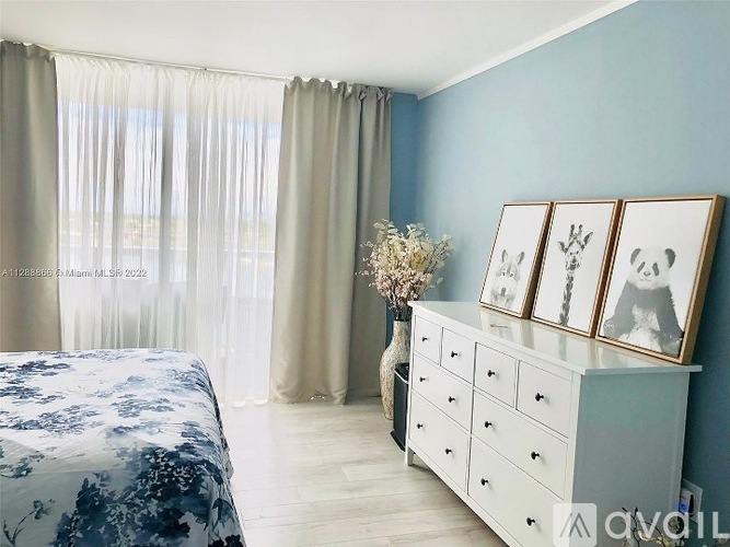 A bedroom with a bed, dresser, and pictures on the wall.