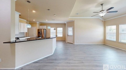 A spacious kitchen with a bar counter and a ceiling fan.
