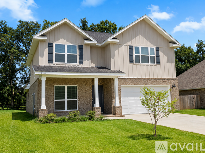A two-story house with a garage and a tree in front.