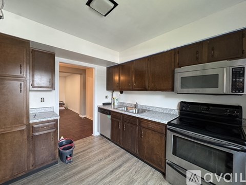 A kitchen with dark wood cabinets and a black stove top oven.