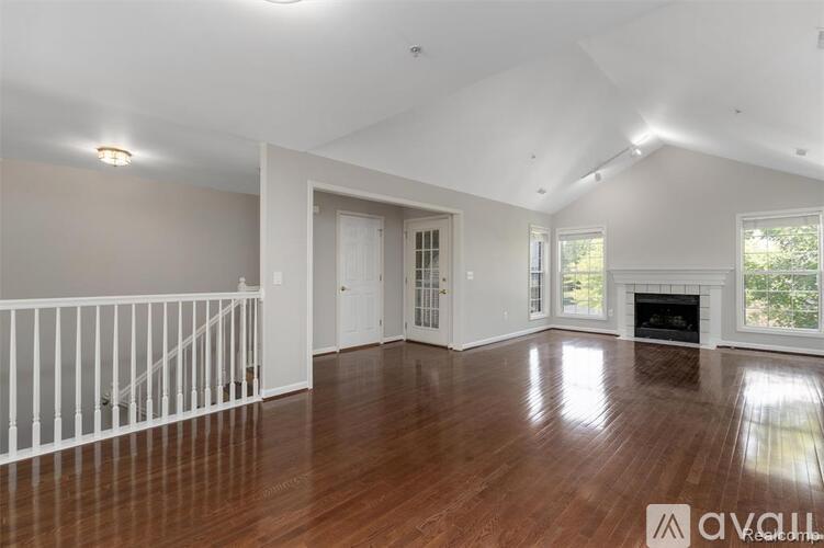 A spacious living room with hardwood floors and a fireplace.