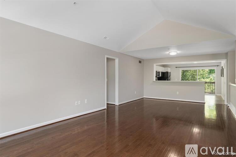 A spacious room with wooden floors and white walls.