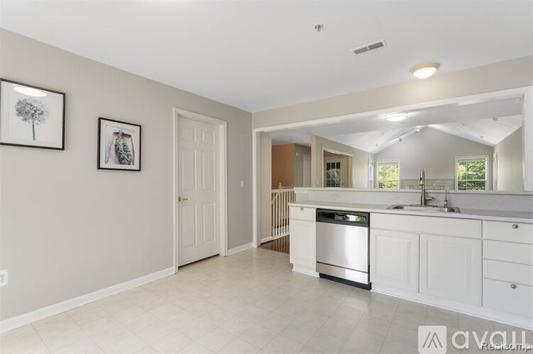 A kitchen with white cabinets and a dishwasher.