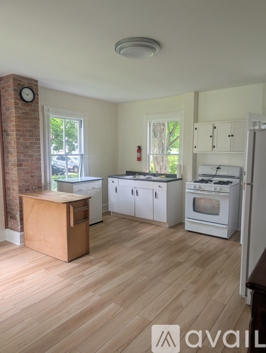 A kitchen with wooden floors and white appliances.