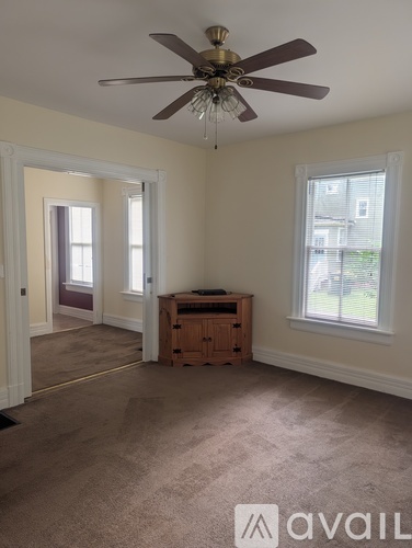 A room with a ceiling fan and a window.