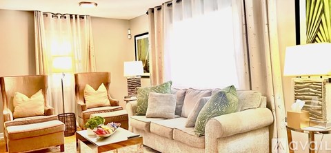 A living room with a couch, chairs, and a coffee table.
