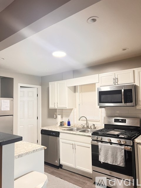 A modern kitchen with white cabinets and stainless steel appliances.