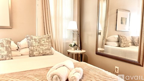 A bedroom with a large bed and a mirror on the wall.