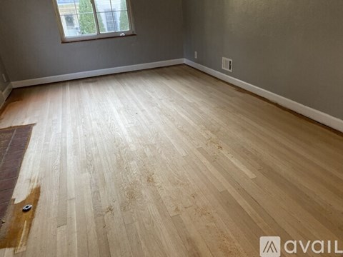 A room with wooden flooring and a window.