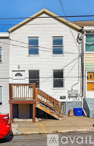 A two-story house with a wooden deck in front.