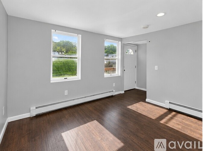 A room with a window and a door is available for rent.