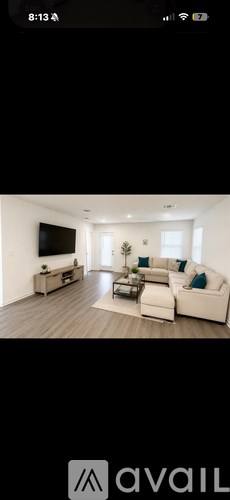 A living room with a white couch and a television.
