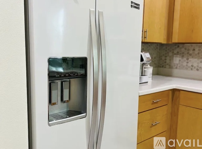 A white refrigerator with a water and ice dispenser in the door.