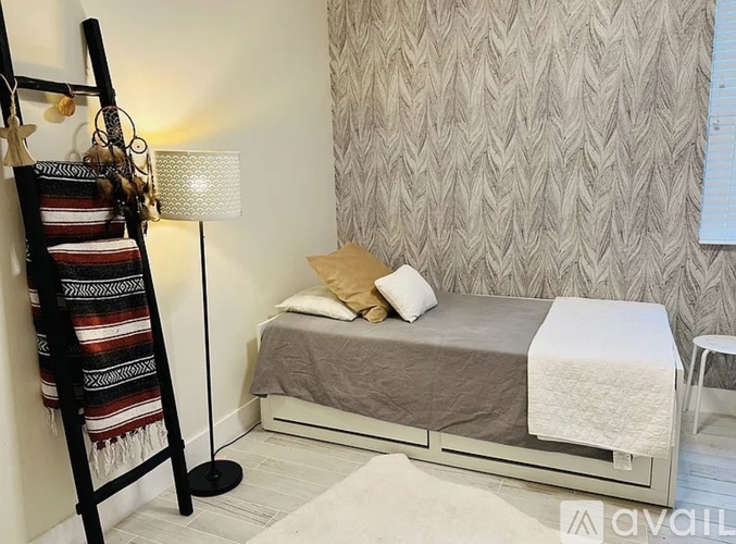 A bedroom with a bed, a chair, and a blanket on the floor.