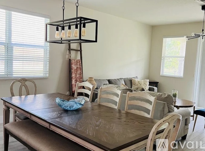 A dining room with a brown table and chairs.