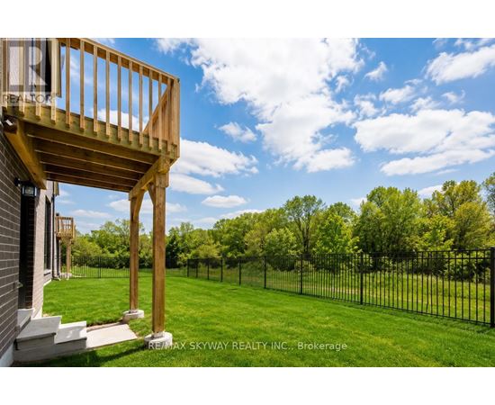 A balcony of a house overlooks a green lawn.