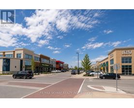 A sunny day at a busy intersection with cars and buildings.
