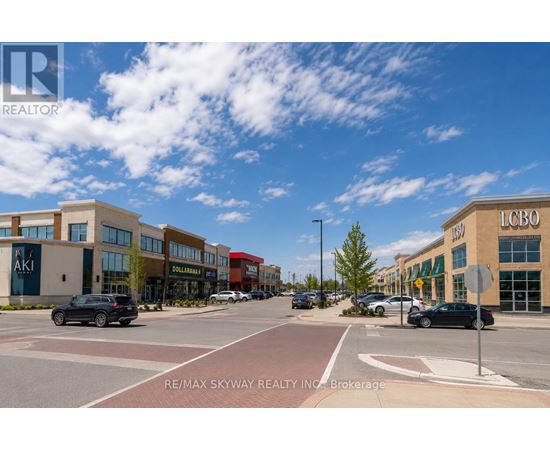 A sunny day at a busy intersection with cars and buildings.