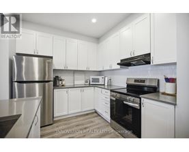 A modern kitchen with white cabinets and stainless steel appliances.