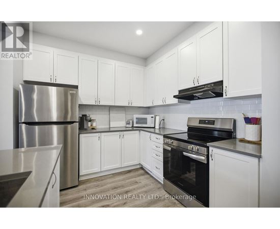 A modern kitchen with white cabinets and stainless steel appliances.