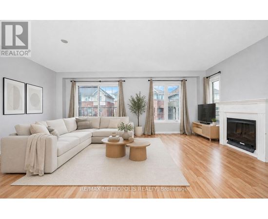 A living room with a white couch, a coffee table, and a fireplace.