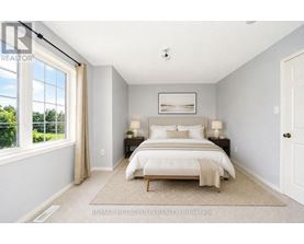 A bedroom with a large bed and a window overlooking a green area.