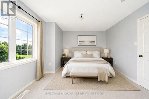 A bedroom with a large bed and a window overlooking a green area.