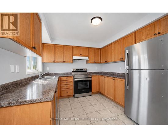A kitchen with wooden cabinets and a granite countertop.
