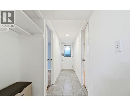 A hallway with a door on the right and a window on the door.