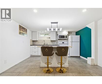A kitchen with white cabinets and a white refrigerator.