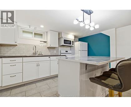 A kitchen with white cabinets and a blue accent wall.