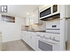 A kitchen with white appliances and cabinets.