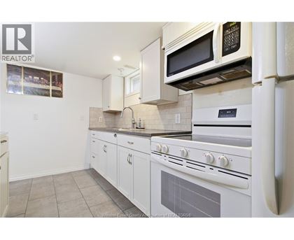 A kitchen with white appliances and cabinets.