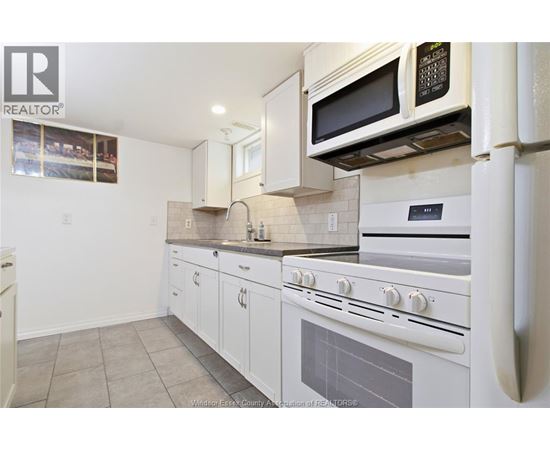 A kitchen with white appliances and cabinets.