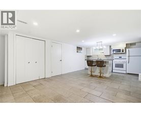 A kitchen with white cabinets and a tile floor.