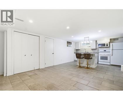 A kitchen with white cabinets and a tile floor.