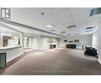 A spacious office room with a carpeted floor and white walls.