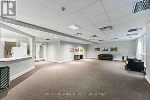 A spacious office room with a carpeted floor and white walls.