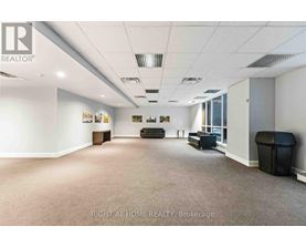 A spacious office room with a carpeted floor and white walls.