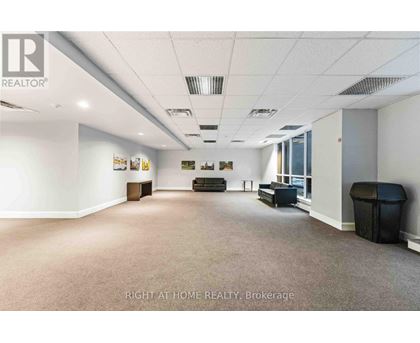 A spacious office room with a carpeted floor and white walls.
